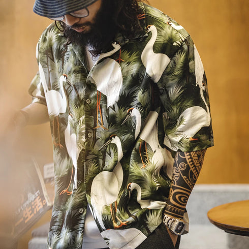Person wearing a shirt with a nature-themed design featuring birds and foliage.